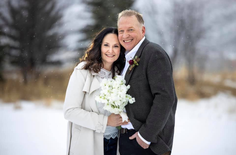 Jacqueline and Jonathan in their wedding attire in a snowy landscape
