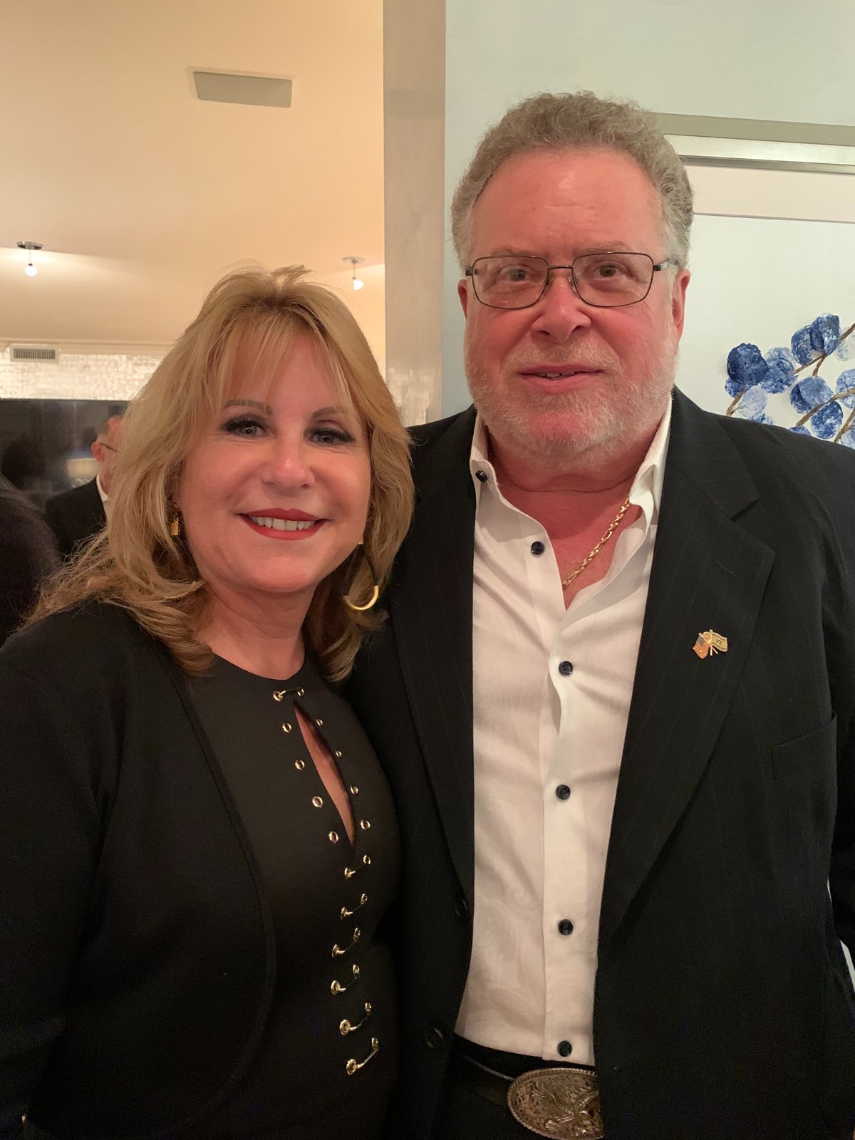 Anna and Mark standing close together and smiling at an evening event