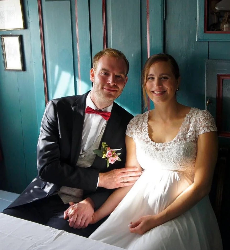 Rebekka and Tim seated together in their wedding attire