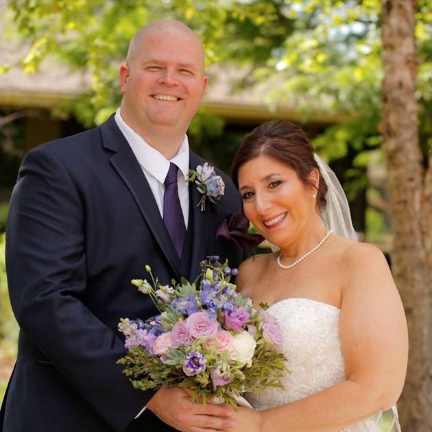 Beth and John in their wedding attire, Beth holding her bouquet