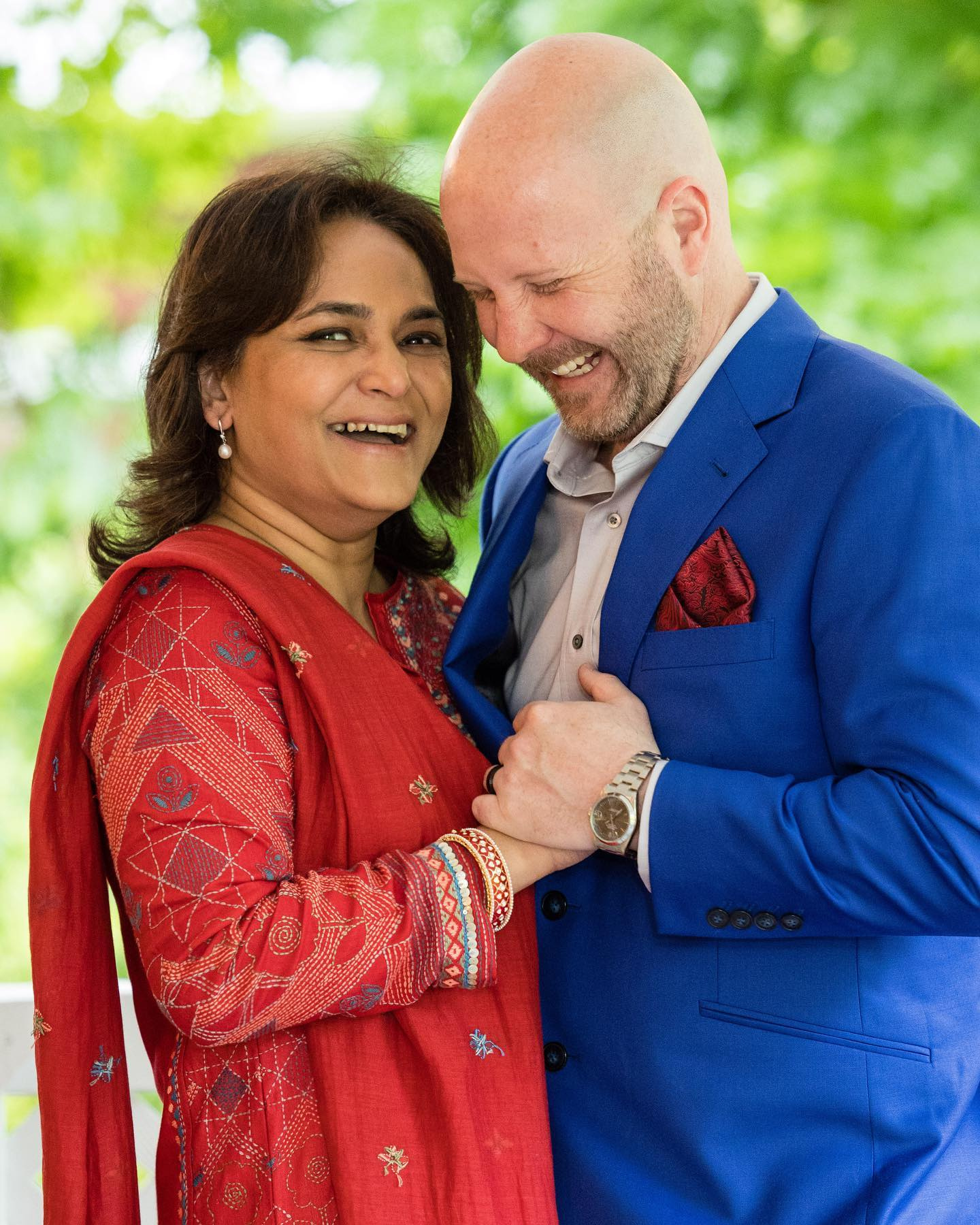 Tina De in red and Levi in blue, smiling together outdoors