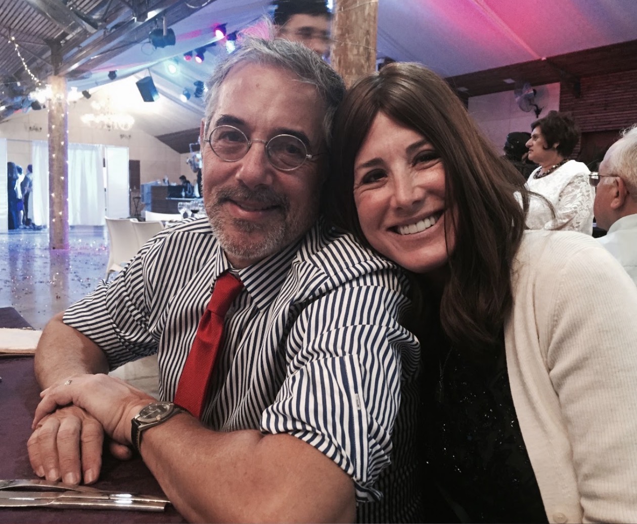 Bari and Michael smiling, leaning close together at a table