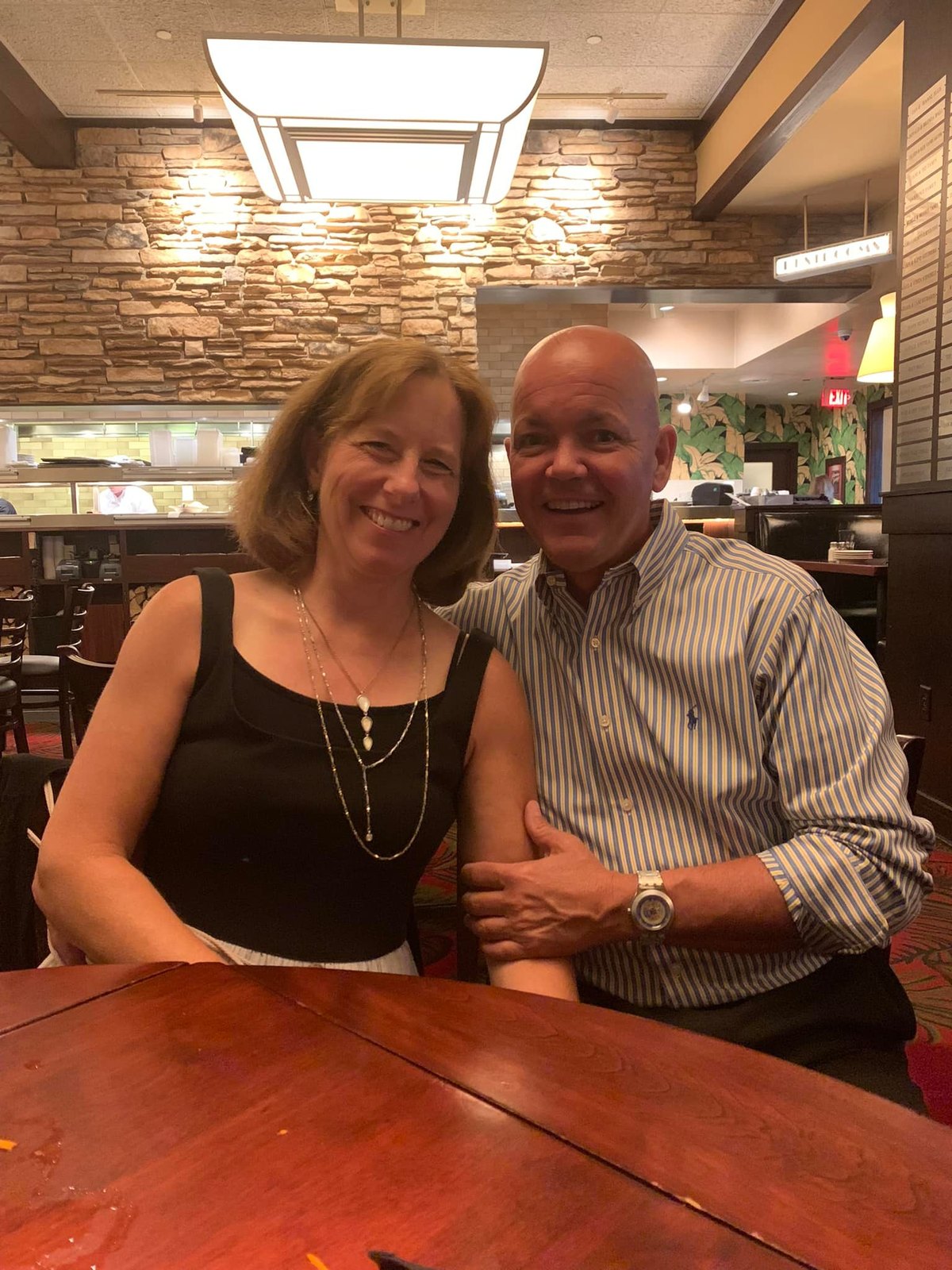 Kathy and Dave smiling side by side at a restaurant table